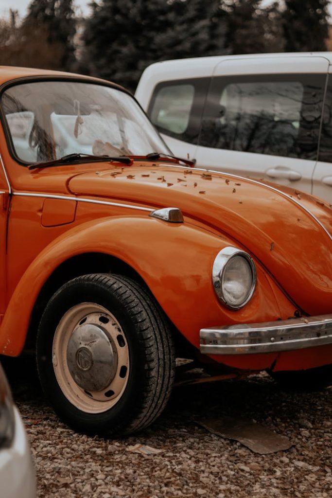 Close-up of a classic orange vintage car parked outdoors.